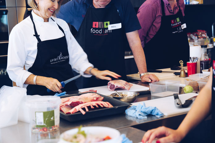 Annette demonstrating how to trim lamb cutlets