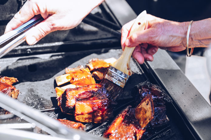 Brushing glaze onto the beef ribs